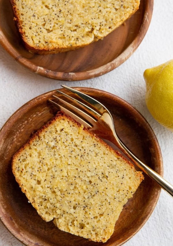 Top down image of two wooden plates with slices of lemon poppy seed bread.