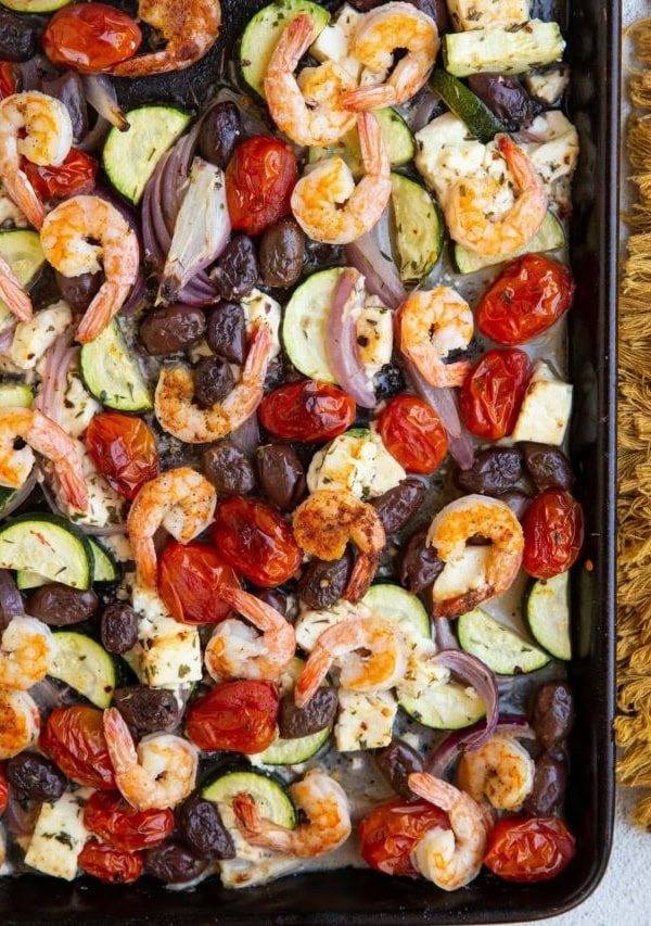 Large baking sheet with shrimp and vegetables for a complete meal, fresh out of the oven.