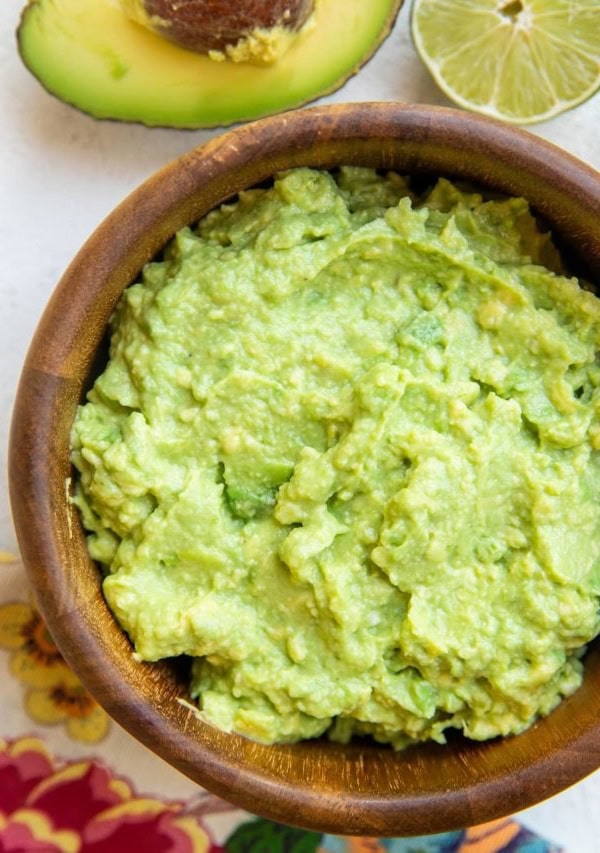 Wooden bowl of the best guacamole recipe ever.