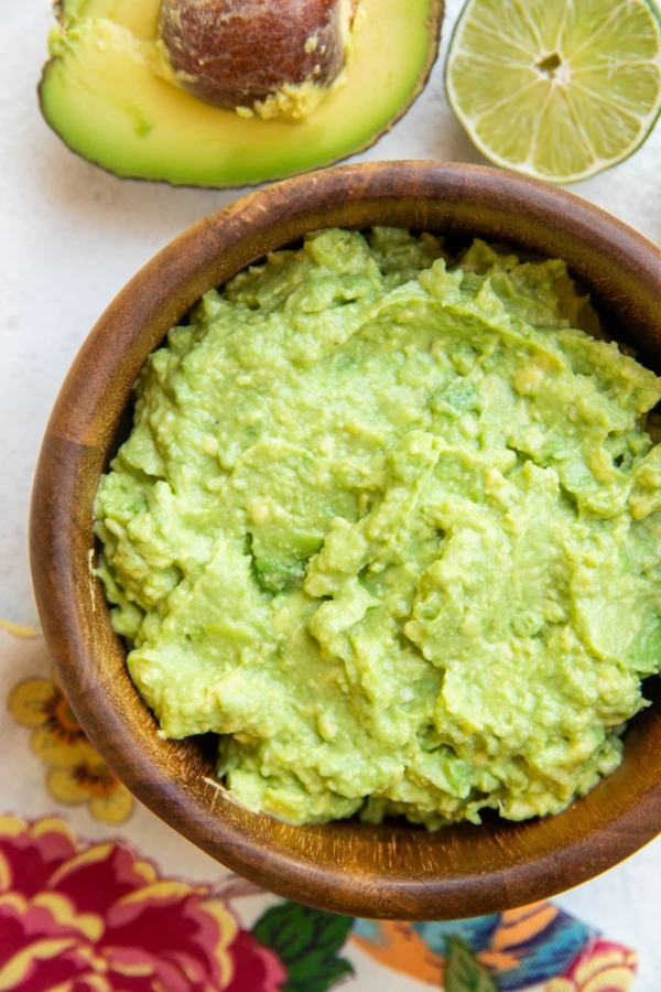 Wooden bowl of the best guacamole recipe ever.