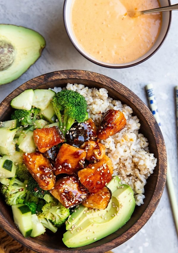 wooden bowl of crispy salmon, rice, and veggies.