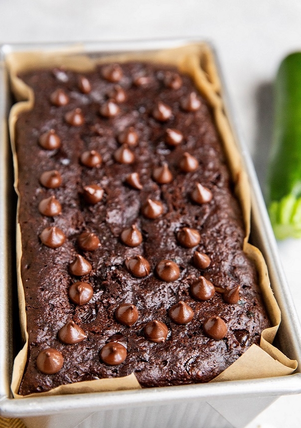 Loaf of double chocolate zucchini bread in a loaf pan fresh out of the oven.