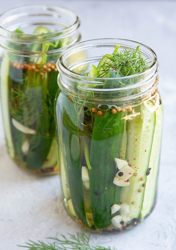 Two large mason jars full of dill pickles