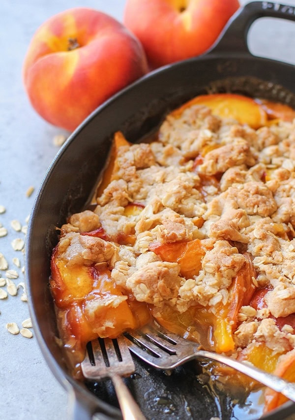 peach cobbler in an oval cast iron skillet.