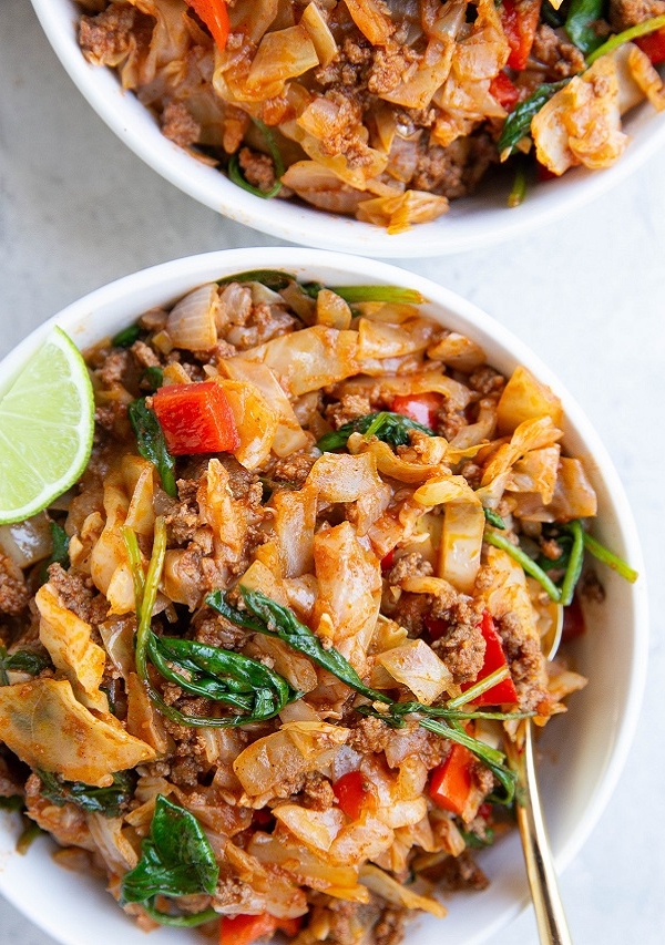 two white bowls of Mexican ground beef and cabbage