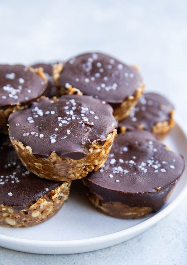 Pile of no-bake peanut butter cups on a white plate.