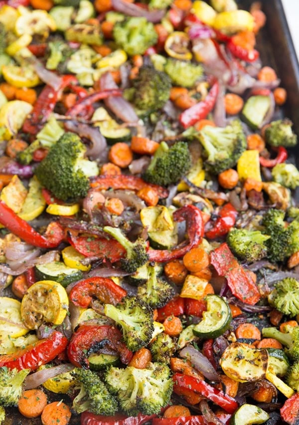 Garlic herb roasted vegetables on a large sheet pan, fresh out of the oven.