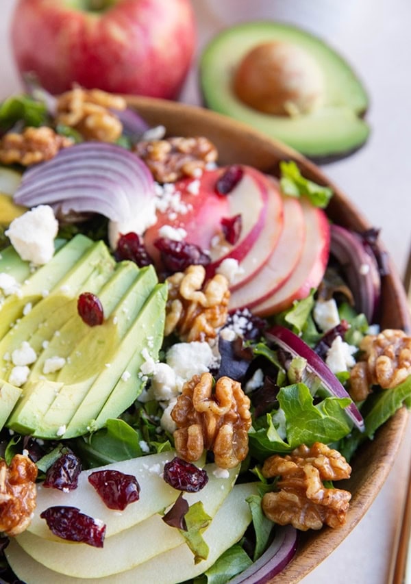 Wooden bowl full of apple spinach salad