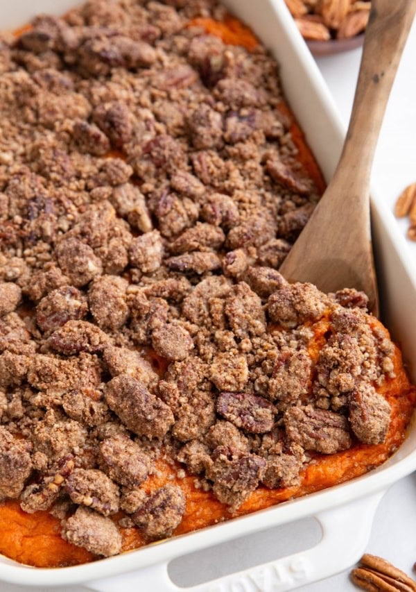 Large casserole dish of sweet potato casserole with pecan crumb topping.