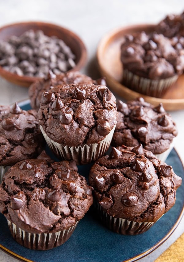 blue plate with a stack of chocolate sweet potato muffins on top.