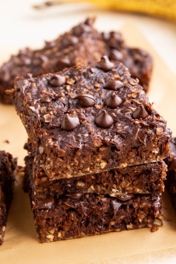 Stack of chocolate oatmeal breakfast bars with more bars in the background.