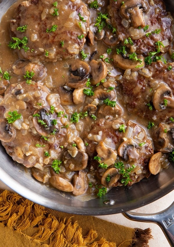 Stainless steel skillet of salisbury steak with mushroom gravy