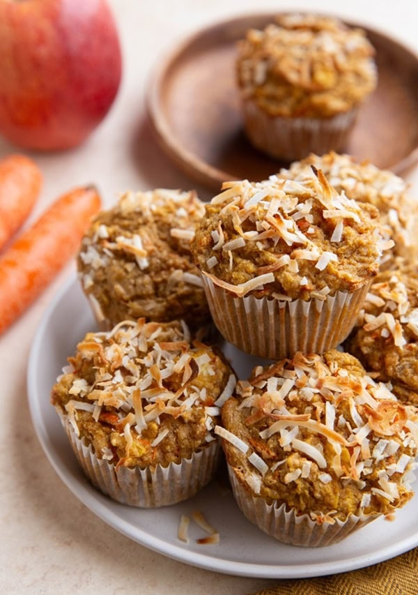 Stack of gluten free carrot muffins on a plate, ready to eat.