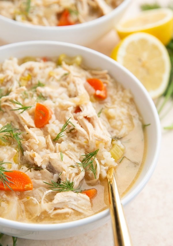 Two white bowls of shredded chicken soup