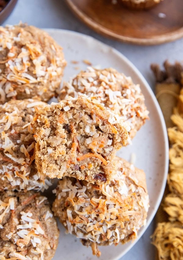 Plate of carrot cake muffins with one sliced in half.