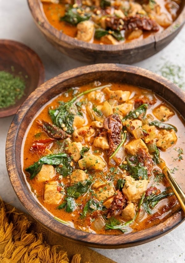 Two wooden bowls of Tuscan chicken soup