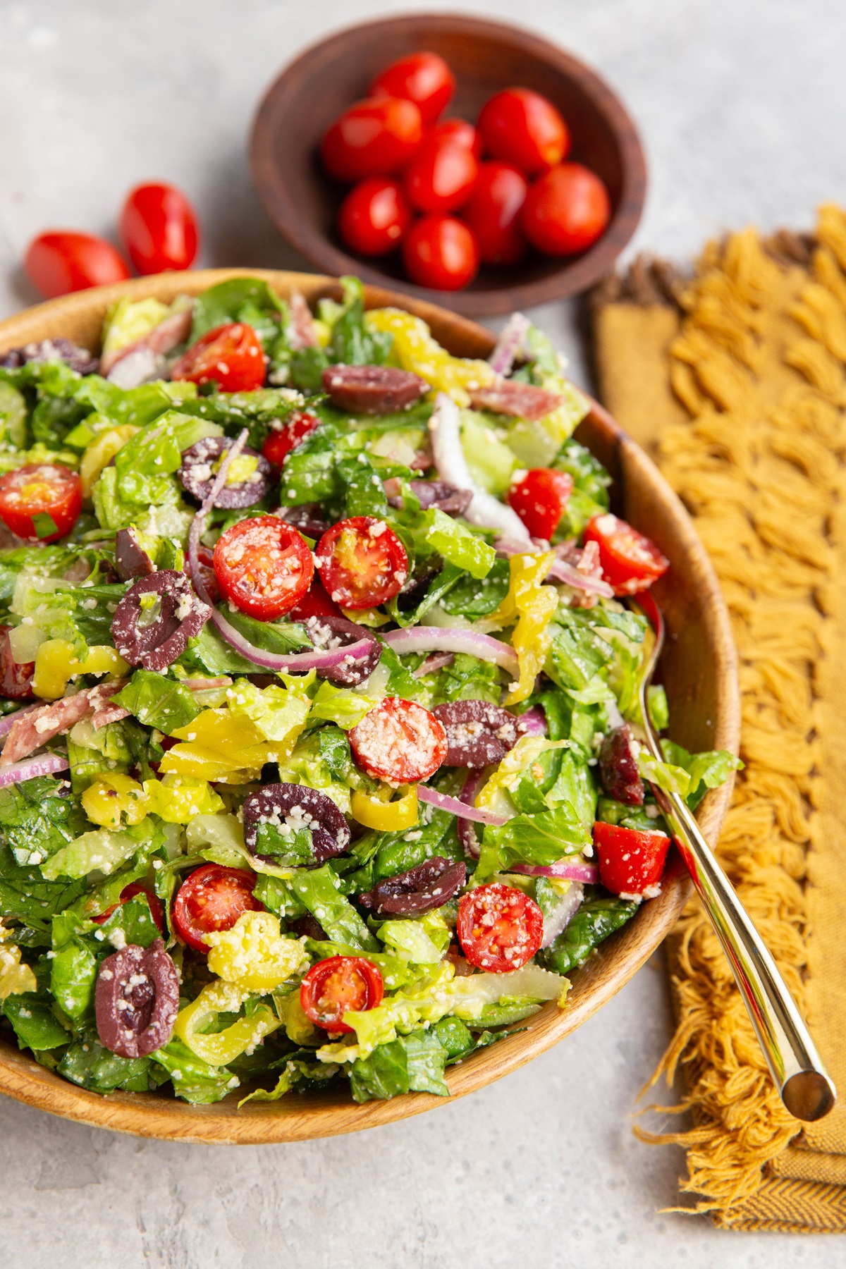 Wooden bowl full of Italian salad with fresh veggies and homemade dressing