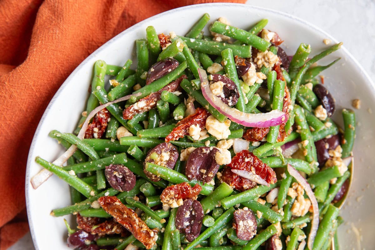 White bowl full of green bean salad.