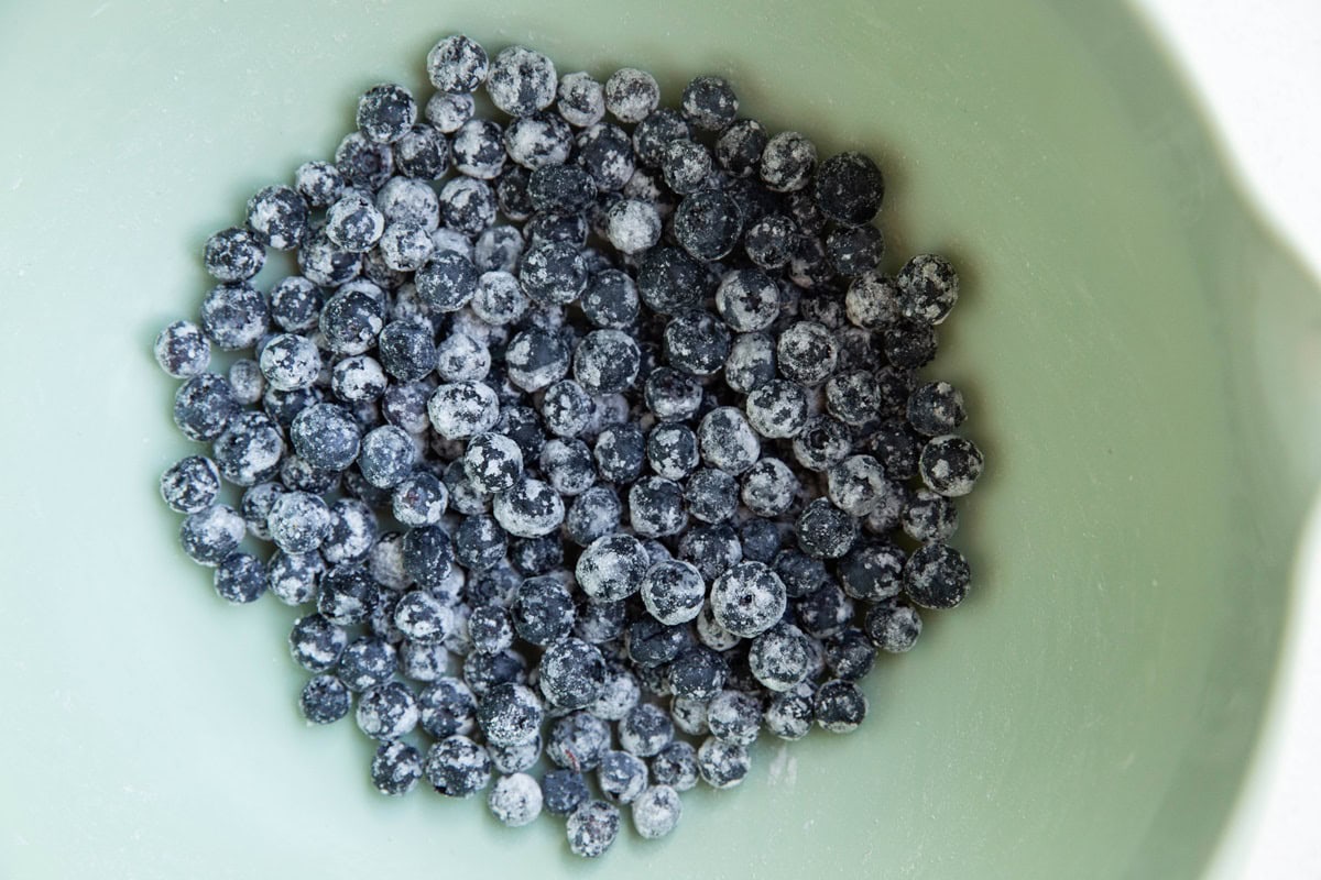 Blueberries tossed with flour in a mixing bowl.