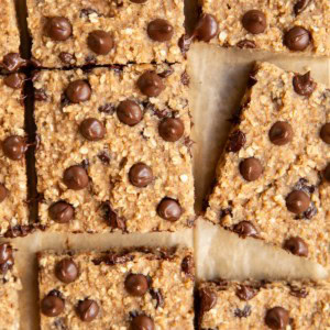 Applesauce bars cut into individual slices on a sheet of parchment paper.