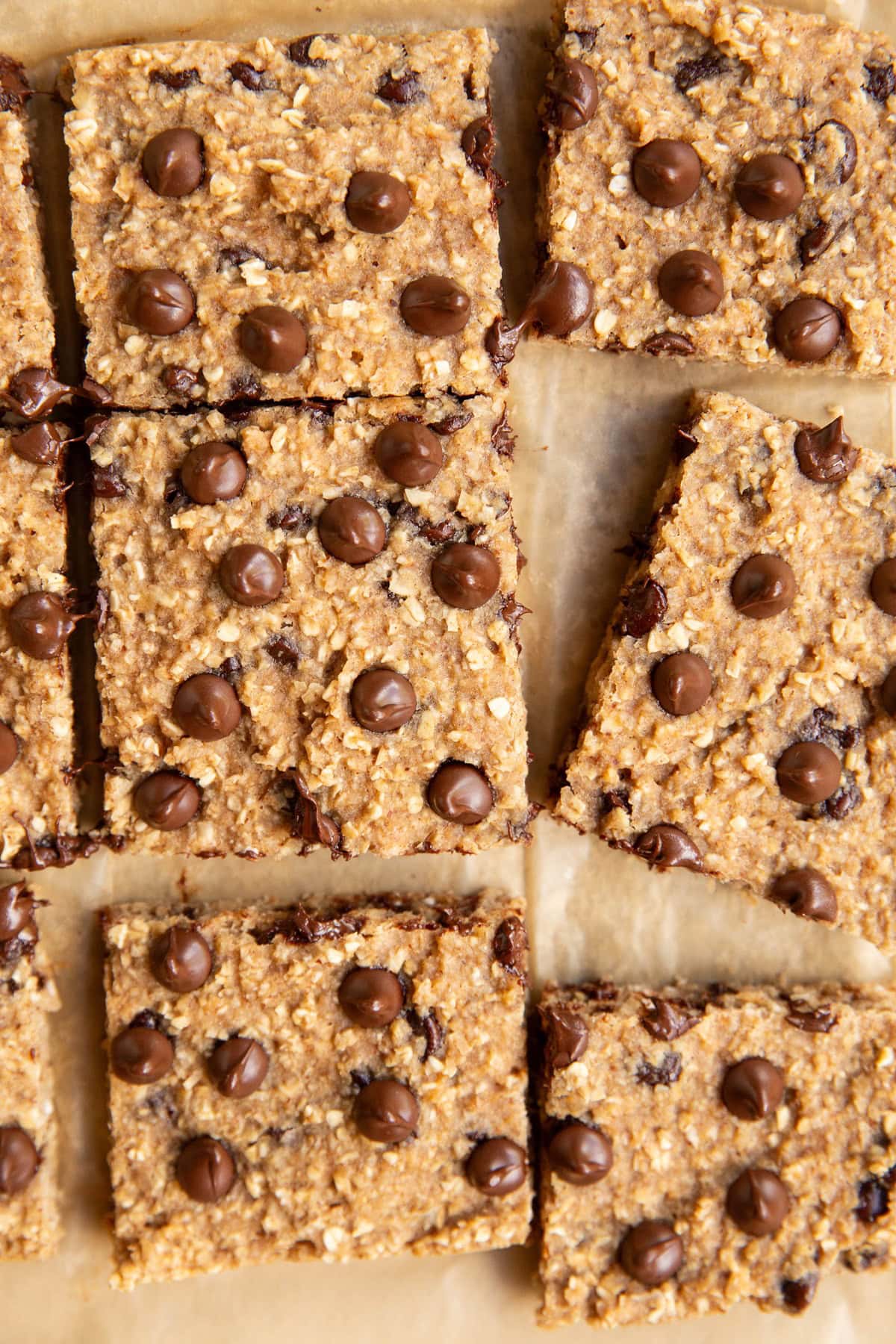 Applesauce bars cut into individual slices on a sheet of parchment paper.