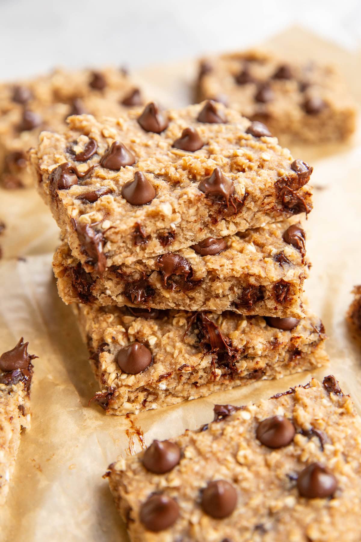 Stack of oatmeal applesauce bars on a sheet of parchment paper.