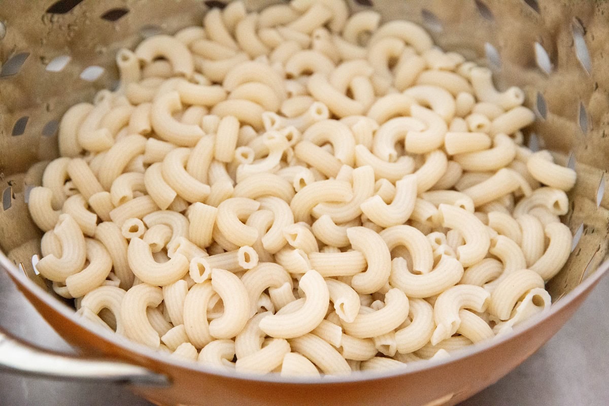 Cooked macaroni noodles in a colander, ready to use,