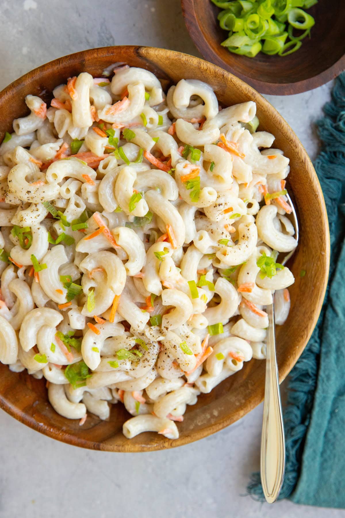 Wooden bowl of macaroni salad, ready to serve.