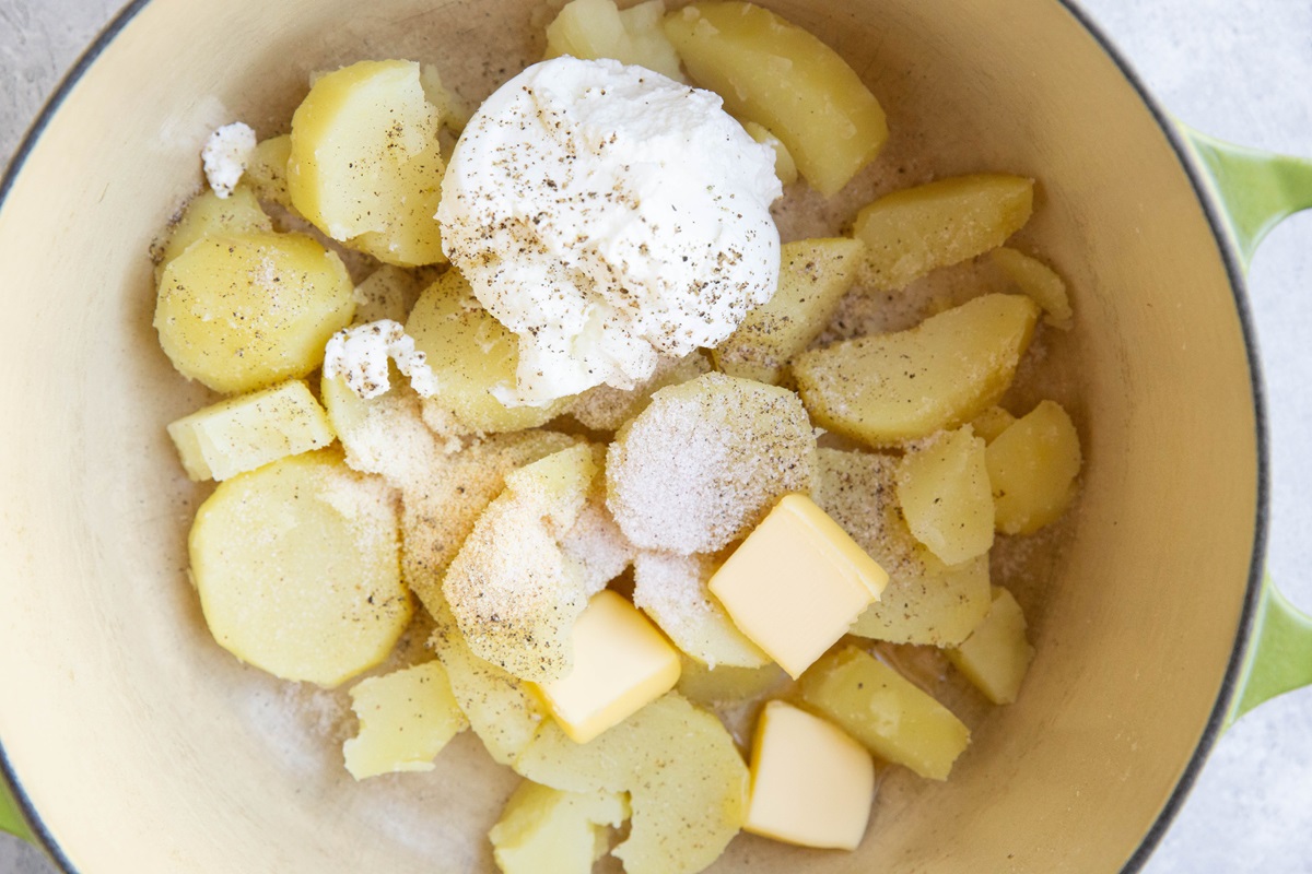 Pot of potatoes with yogurt, butter and seasonings inside.