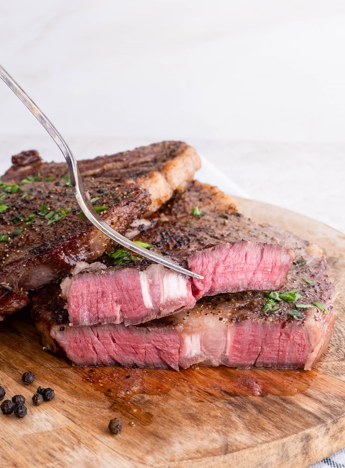 medium-rare ribeye steak cut in half on a cutting board