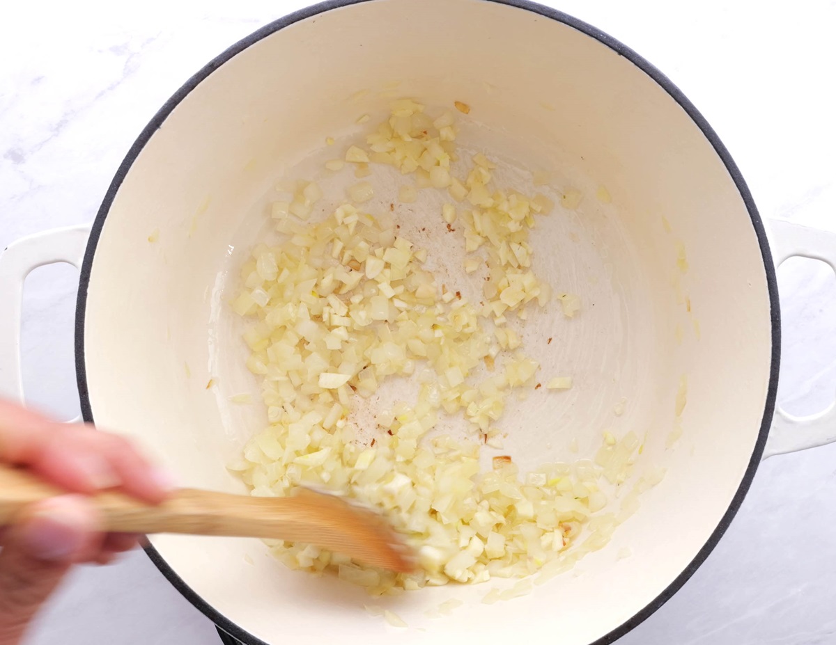 Sautéing onion and garlic in a large pot.