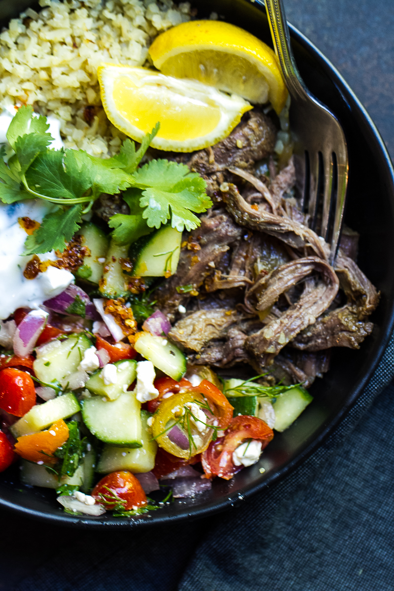 Shredded gyro meat in a bowl with rice and salad.