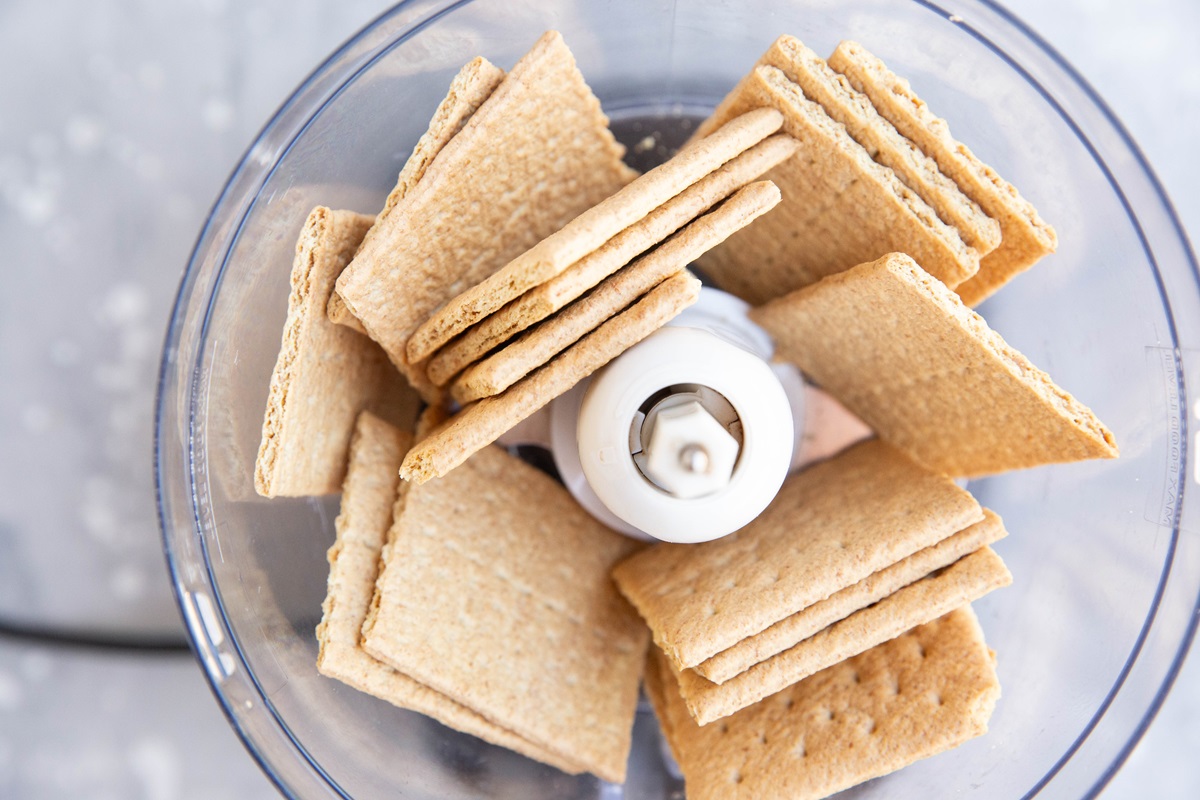 Graham crackers in a food processor, ready to be processed into crumbs.