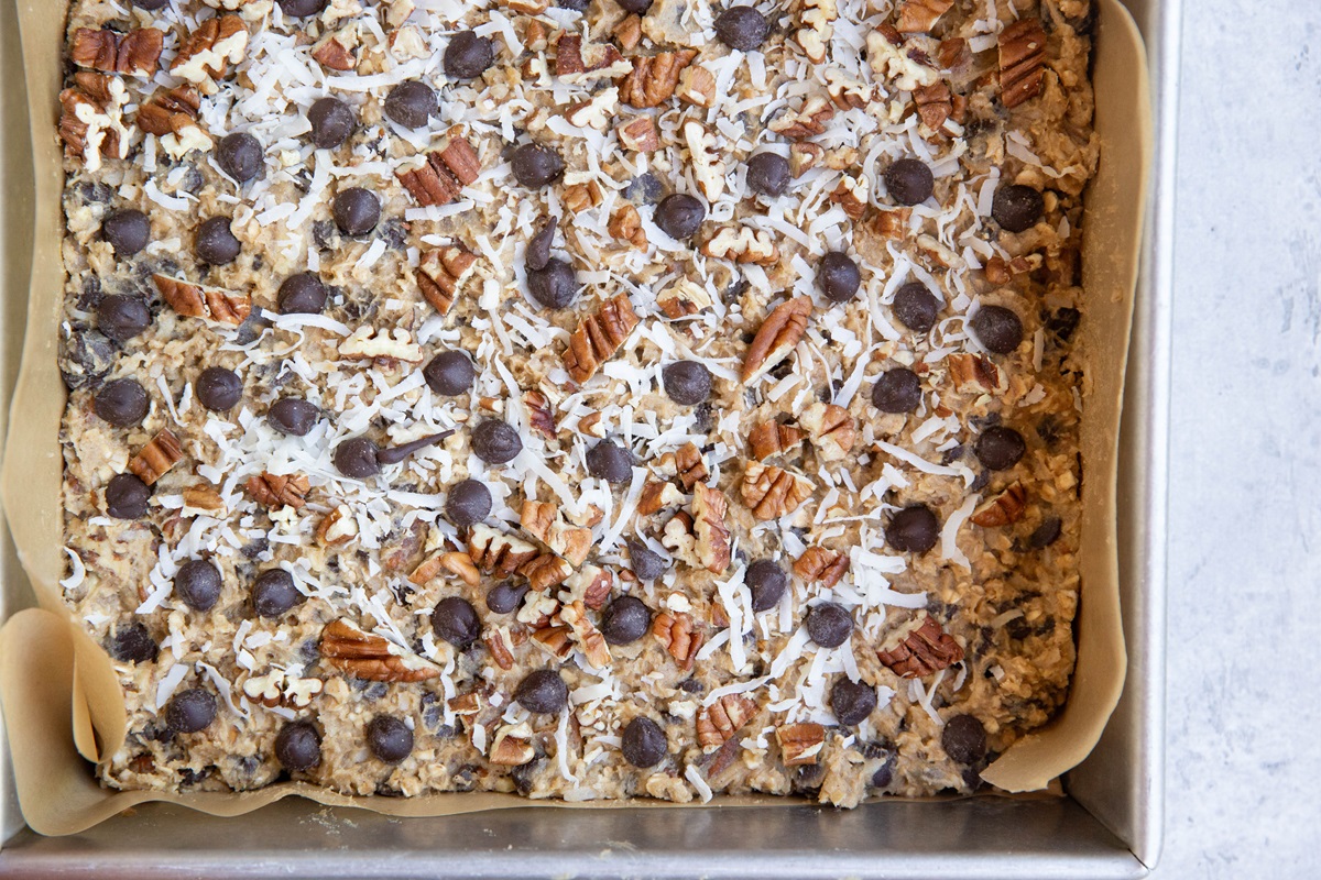 Baking pan full of cookie dough, spread into an even layer, ready to go into the oven.