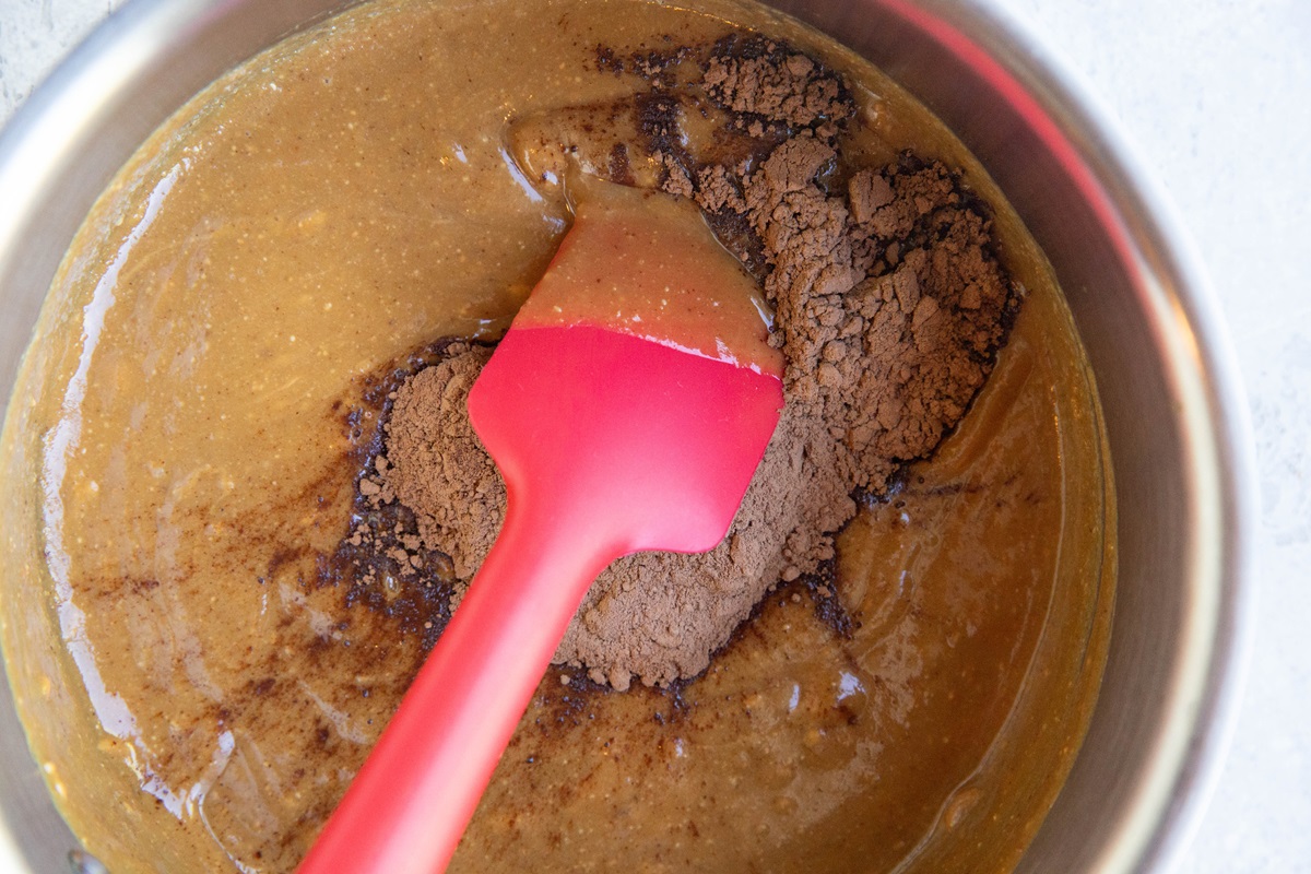 Cocoa powder in a saucepan on top of peanut butter mixture.
