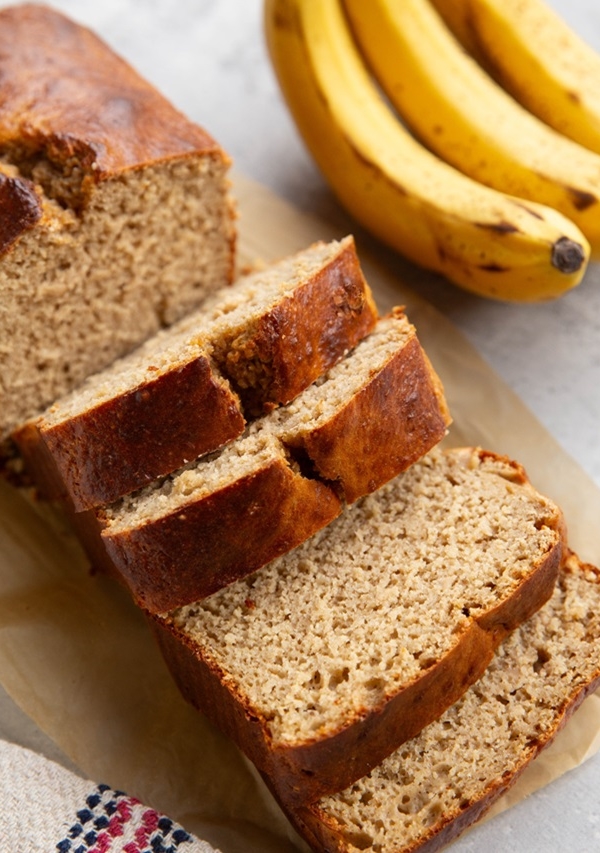 Protein banana bread recipe cut into slices on a sheet of parchment paper.