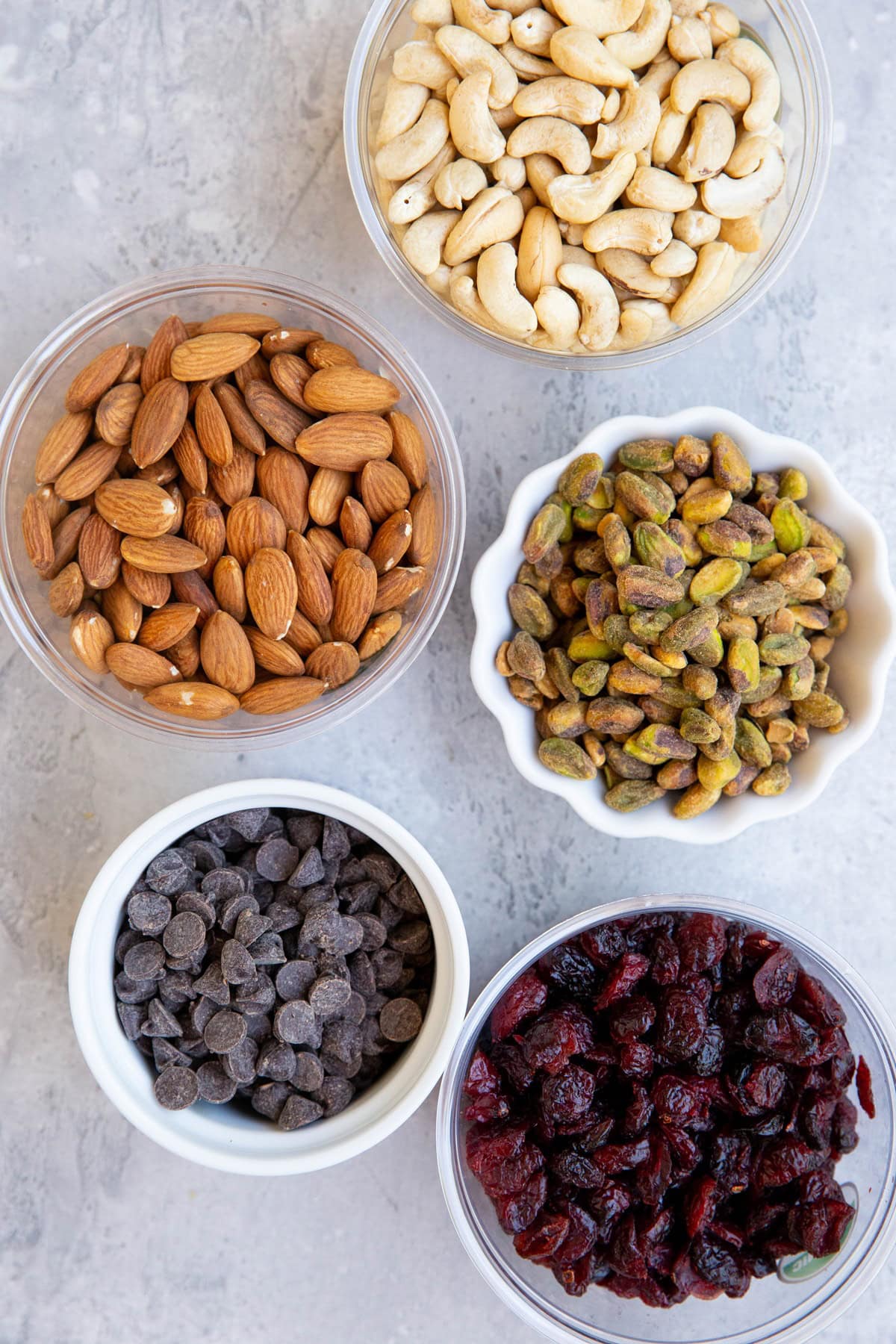 Bowls of nuts and chocolate chips and dried cranberries to make trailmix.