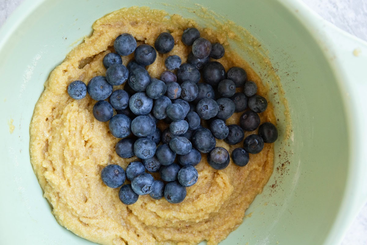 Mixing bowl of cookie dough with blueberries on top.