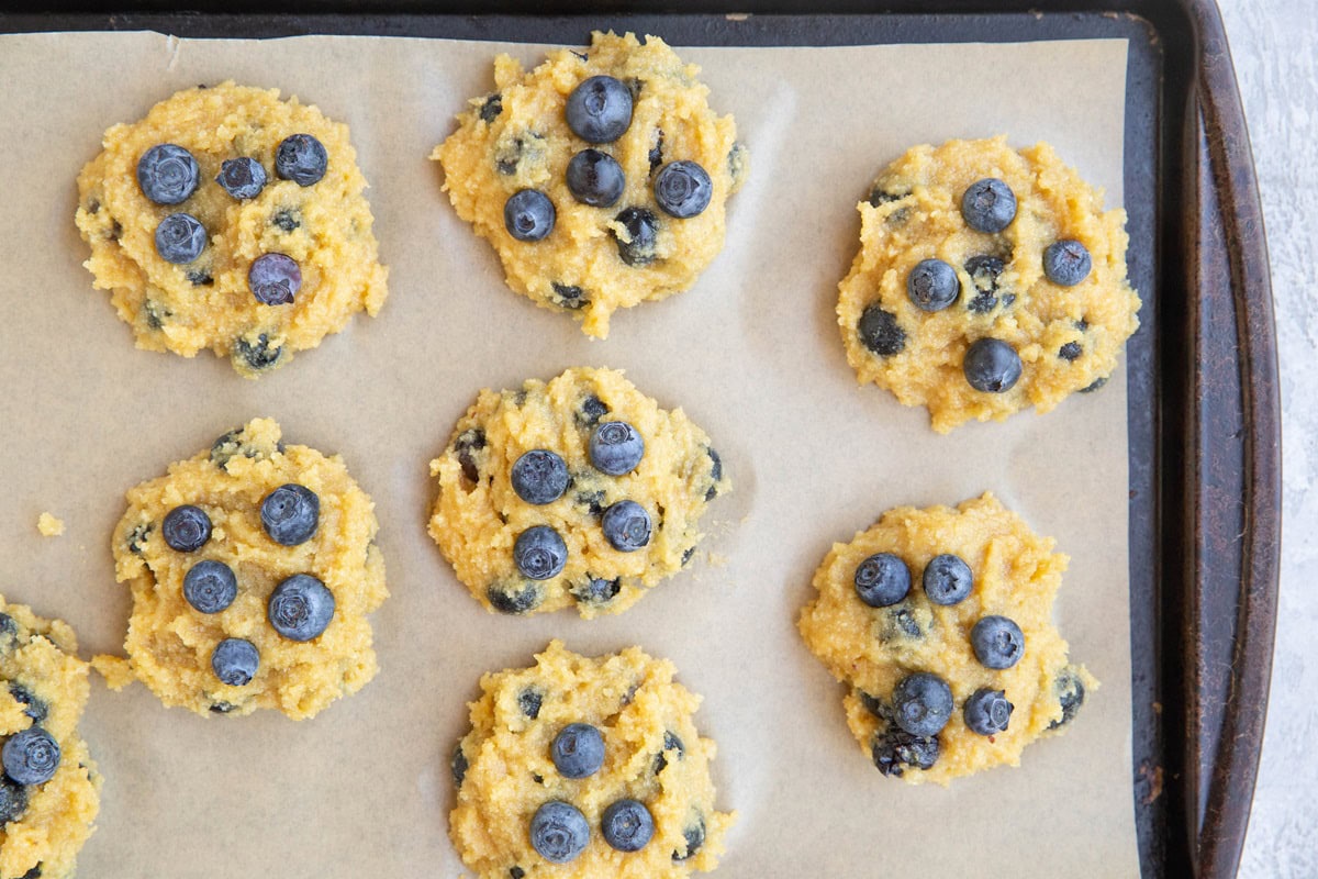 Mounds of blueberry cookie dough on a baking sheet.