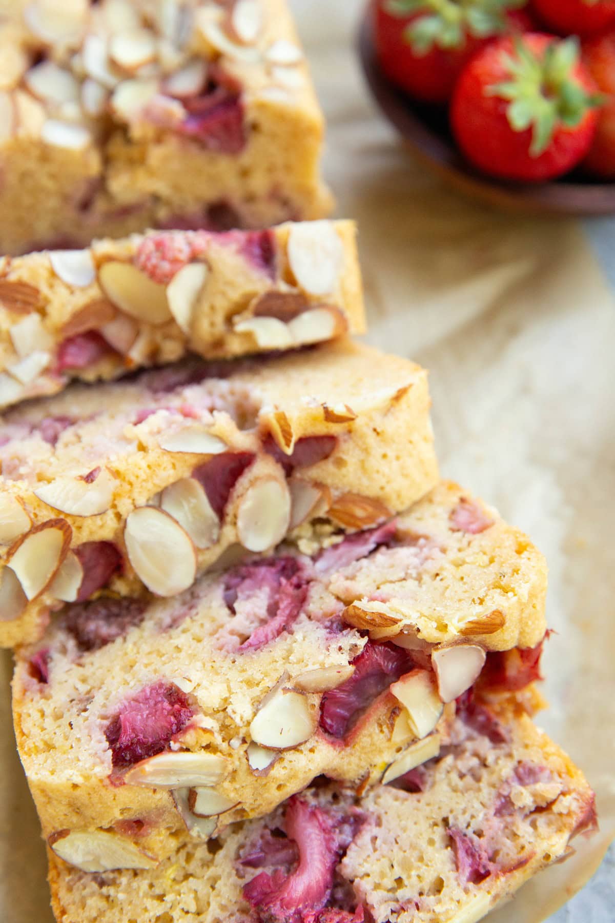 Loaf of almond flour strawberry bread cut into slices, ready to eat.