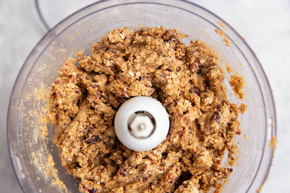 Food processor with cranberry almond protein bite mixture all mixed up. Ready to be turned into balls.