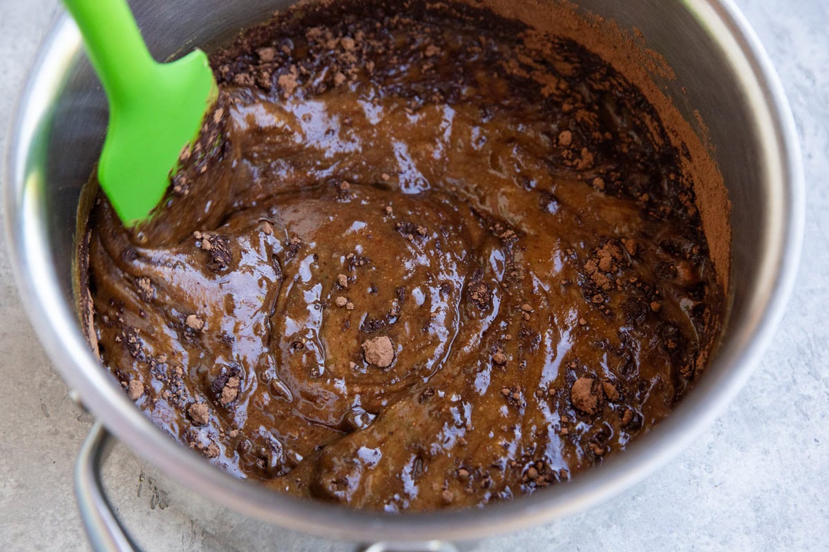 Cocoa powder being mixed into the wet ingredients for the cookie bars.