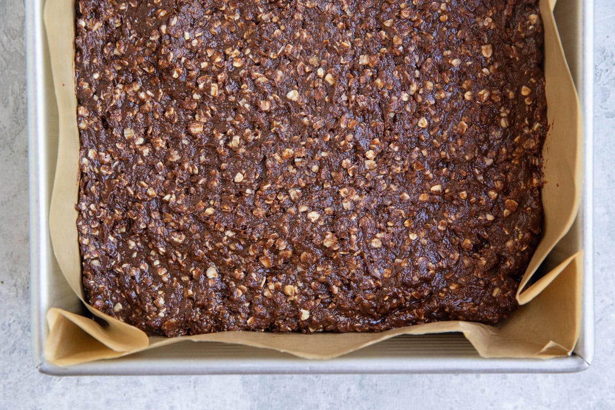 Baking dish with no bake cookie bar mixture pressed into it, ready to go into the freezer.