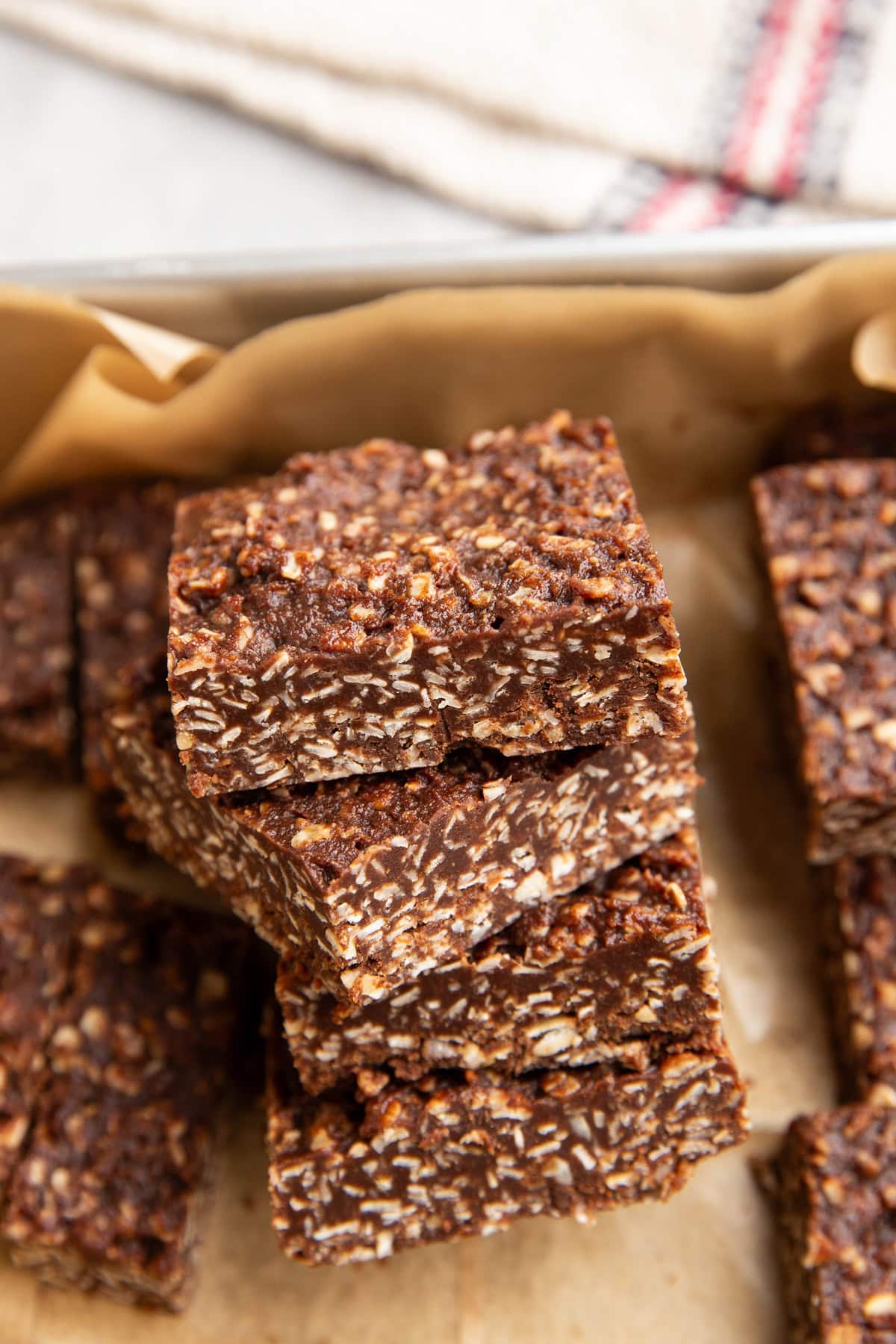 Stack of no bake cookie bars in a baking dish, ready to eat.