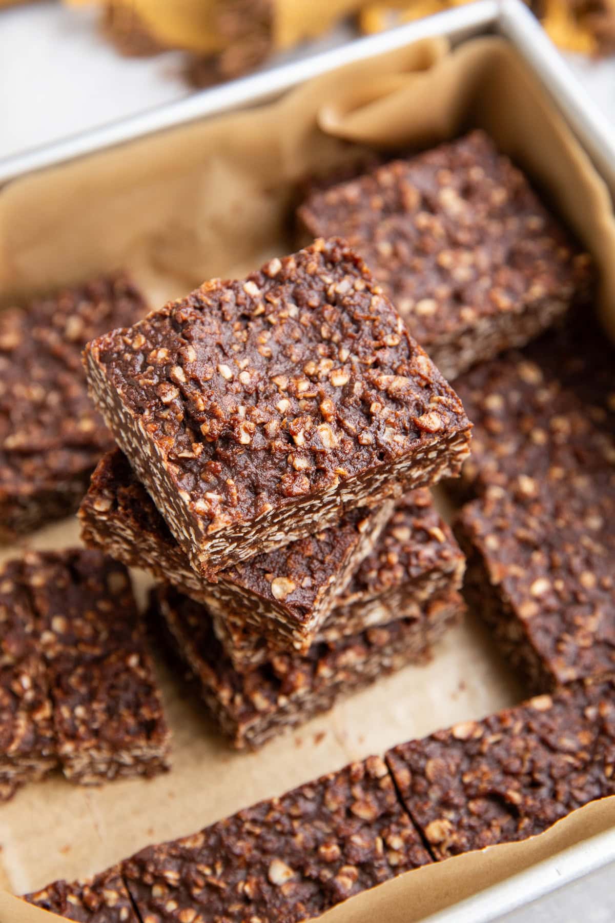 Stack of no-bake cookie bars in a baking dish, ready to eat.