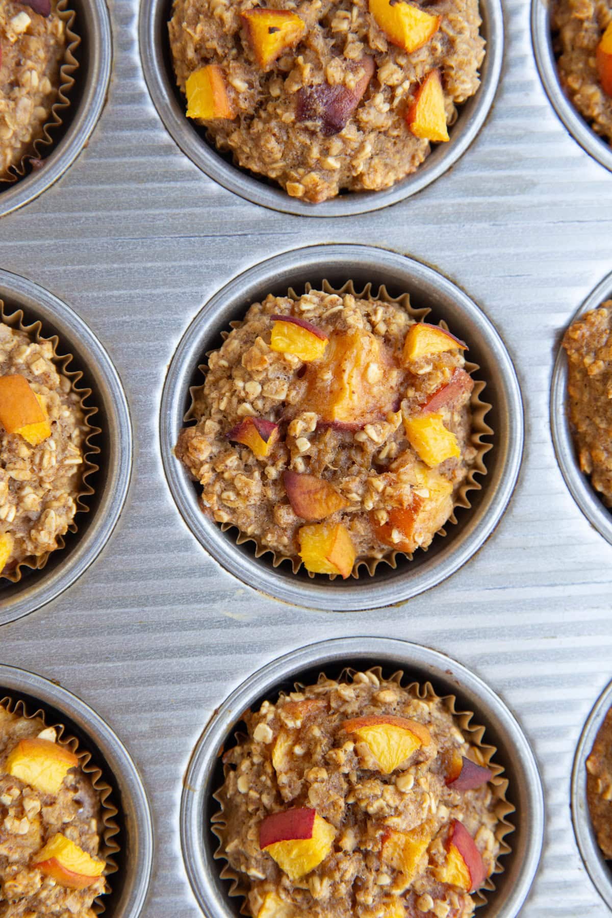 Muffin tray of peach muffins.