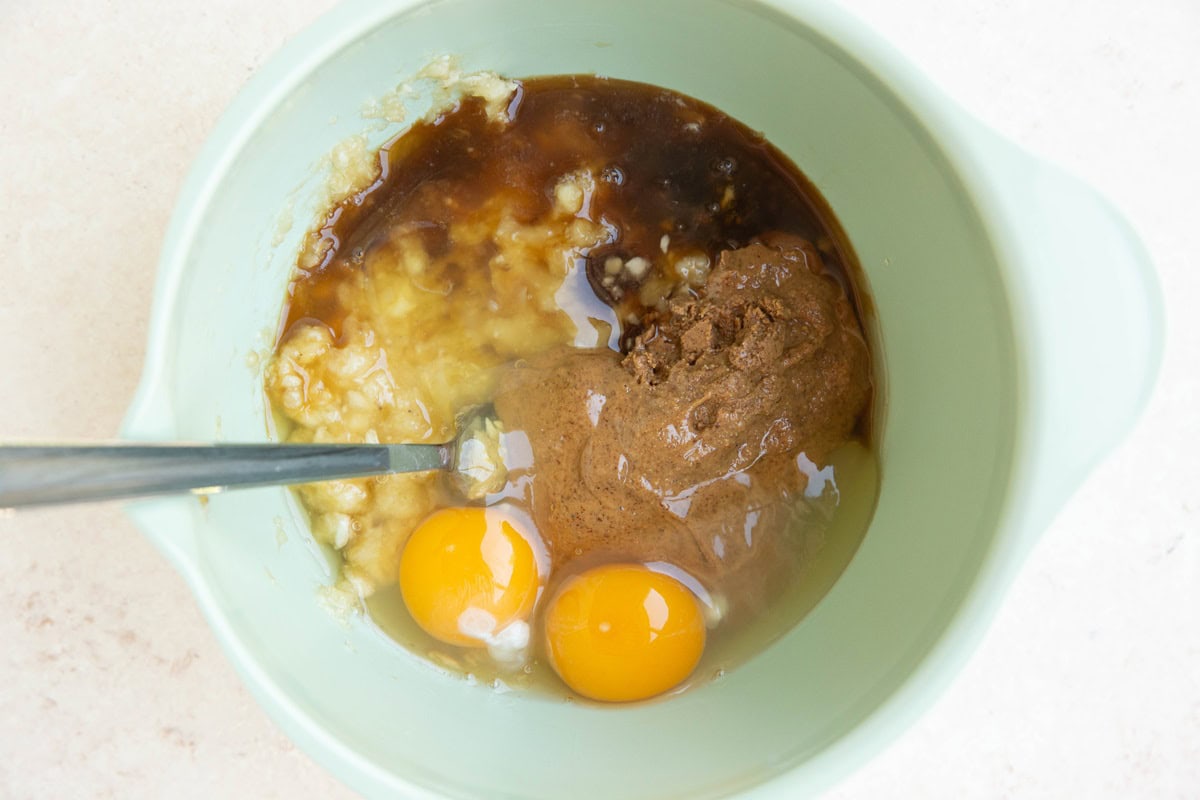 Wet ingredients for peach oatmeal cups in a mixing bowl, ready to be mixed up.