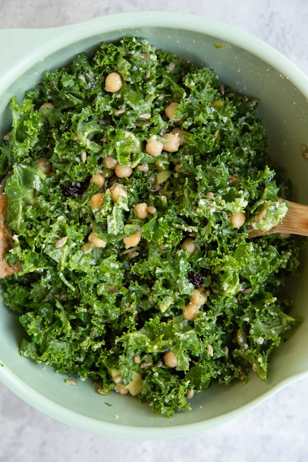 Large bowl with kale salad inside, all tossed up and ready to eat.