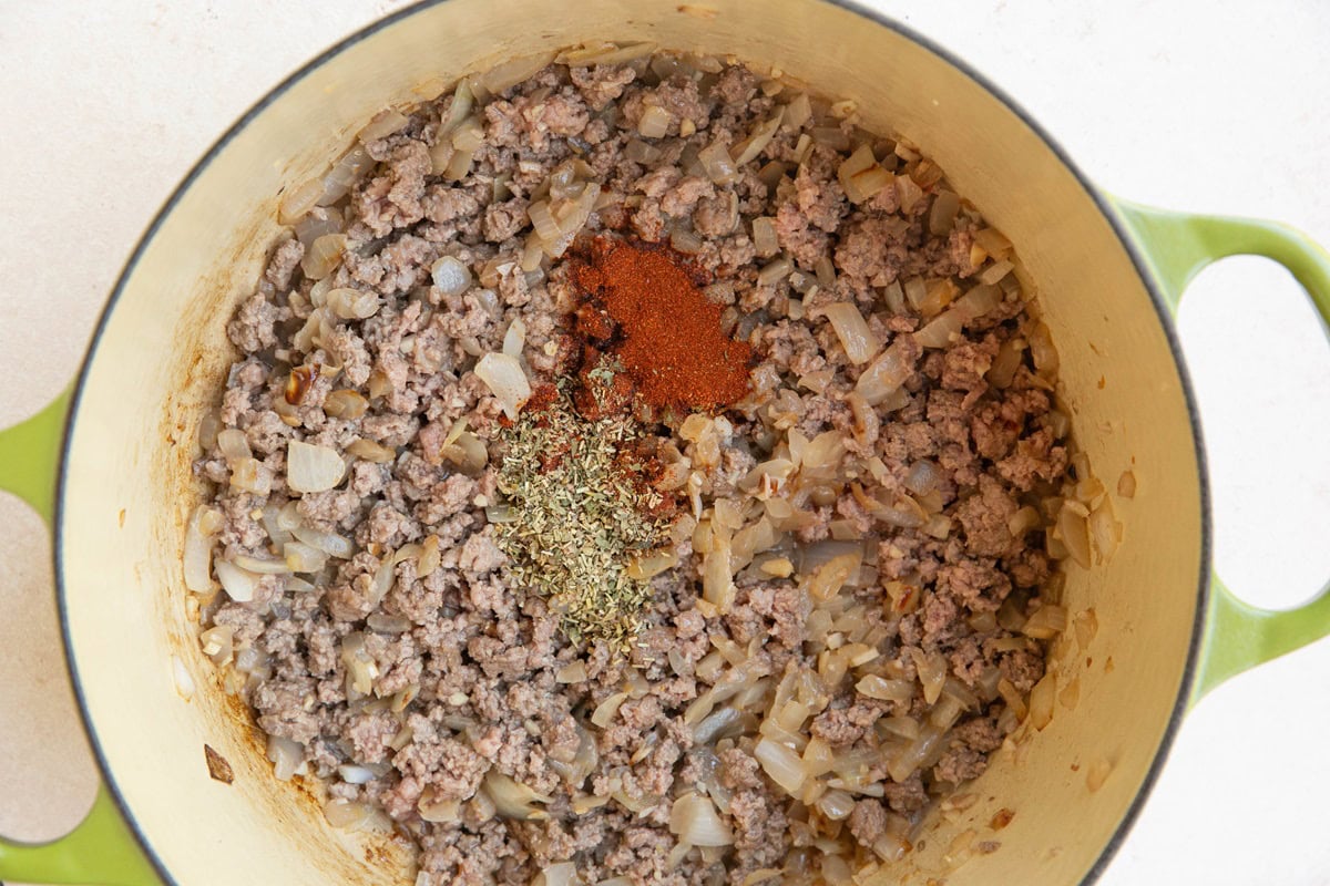 Onion, garlic, ground beef and seasonings cooking in a Dutch oven.