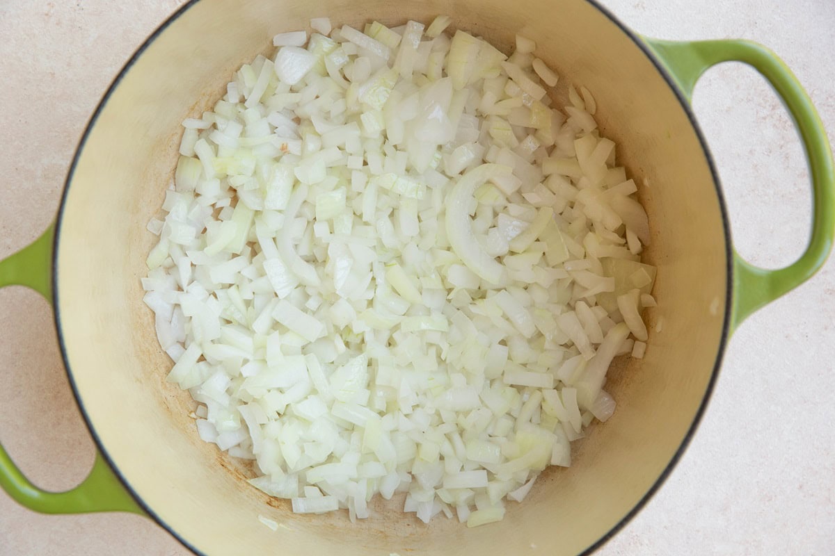 Onion and garlic cooking in a Dutch oven.